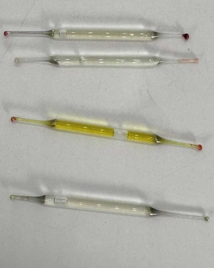 What’s this? Found under a bathroom vanity during remodeling—small glass tubes, 2 inches long, filled with liquid. Any ideas?